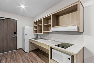 Una cocina moderna con refrigerador integrado, un lavamanos y un microondas.