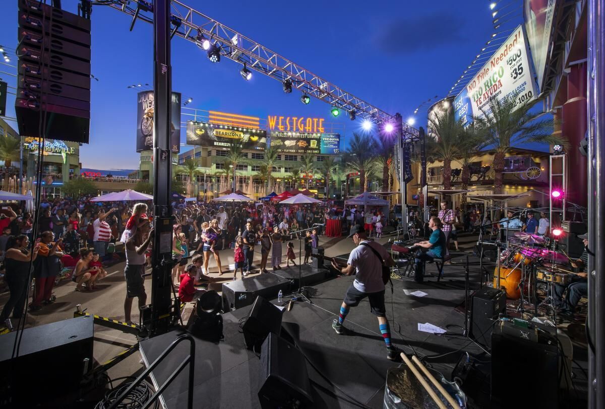 A stage with musicians performing, surrounded by an audience.