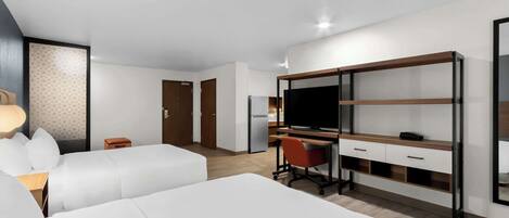 Une chambre d’hôtel moderne avec deux lits blancs, un bureau avec un ordinateur, une télévision et une armoire.