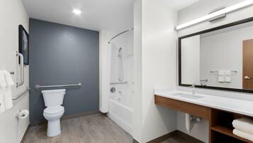 A modern bathroom with a toilet, shower, and sink.