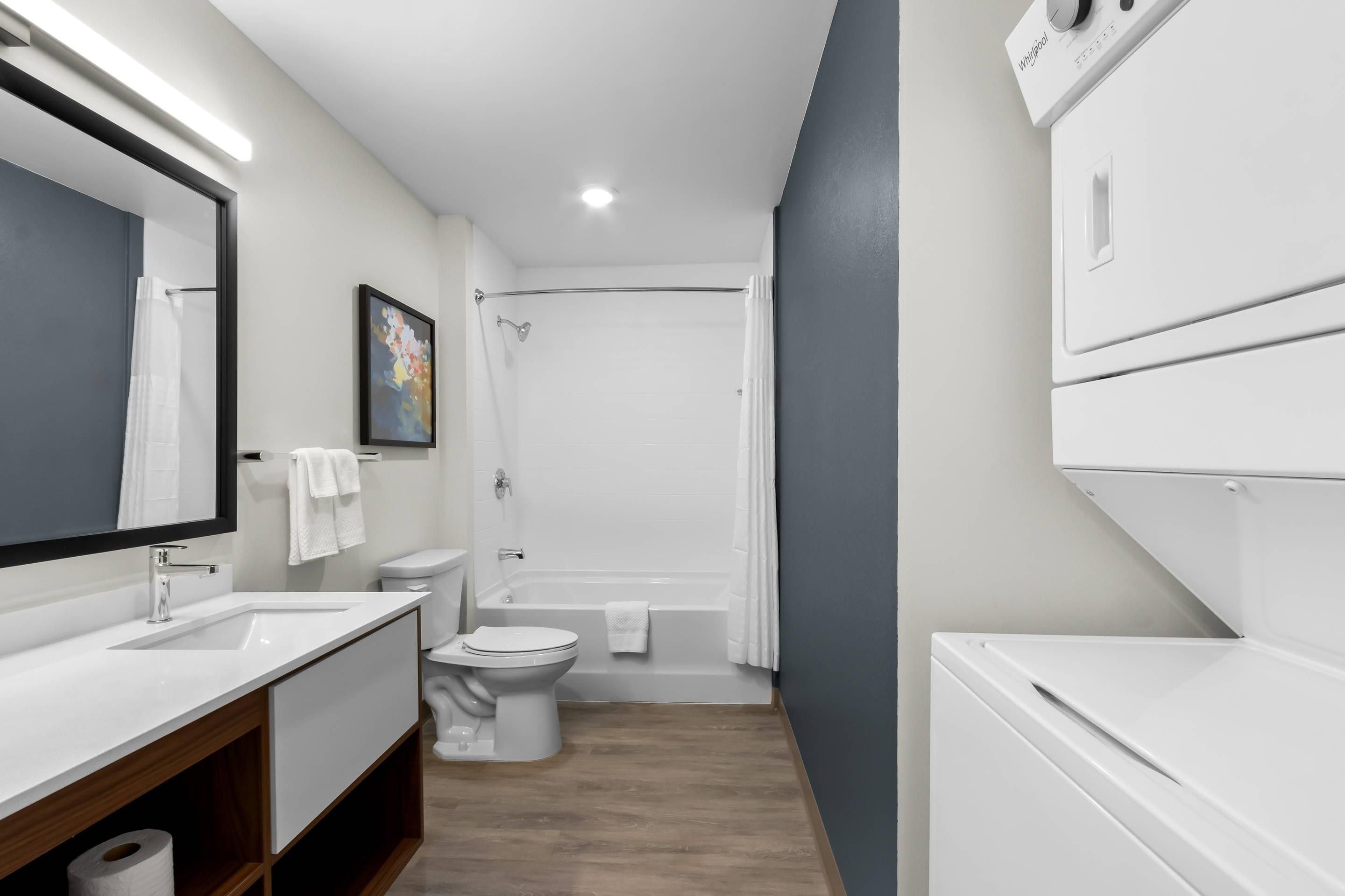 A modern bathroom with a sink, toilet, and shower.