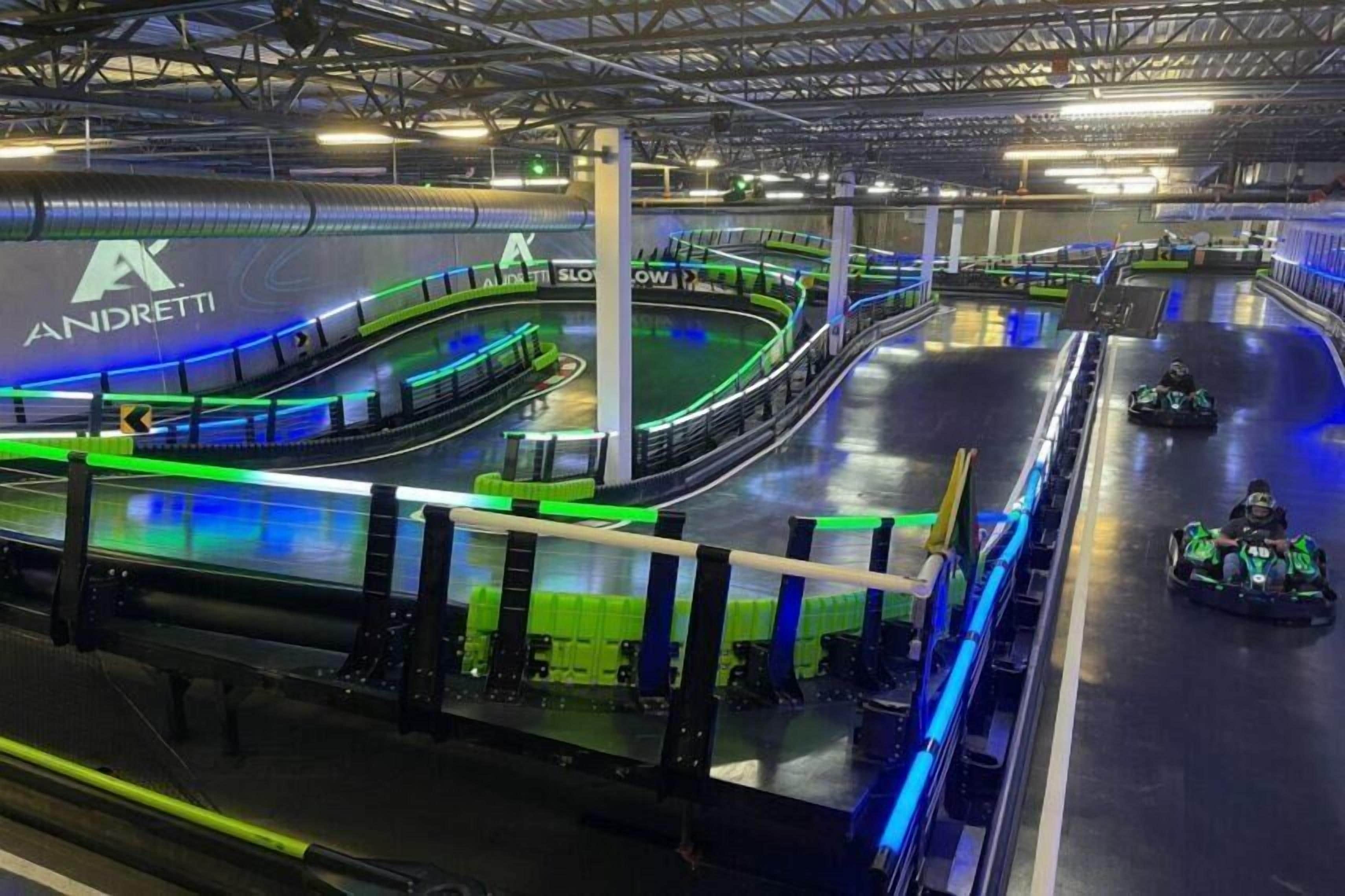 A go-kart racing track with a green and black color scheme and a visible logo.