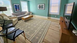 Un salon avec un canapé, une table basse et un meuble pour la télévision.