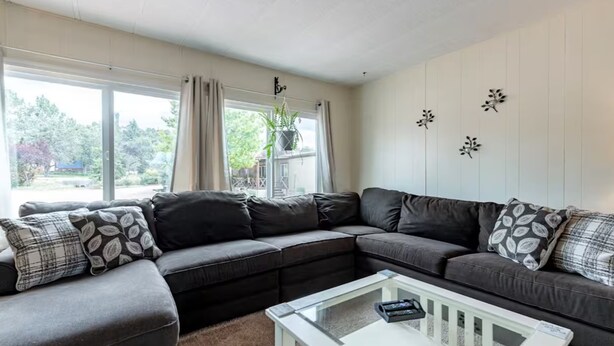 A living room with a sectional sofa, a glass coffee table, and a view of the outdoors. - Central, Quiet, Pet-Friendly ~ Inn the Mountains (Payson)