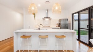 A modern kitchen with a large island, stainless steel appliances, and pendant lighting. - Pet-friendly. Bright and Spacious Dunsborough Home (Dunsborough)