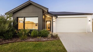 A modern two-story house with a garage, a well-maintained lawn, and a clear sky. - Pet-friendly. Bright and Spacious Dunsborough Home (Dunsborough)