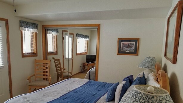 A bedroom with a large bed, a chair, a desk, and a lamp. - Cascade Three Bedroom Three Bath C03 (Ouray)