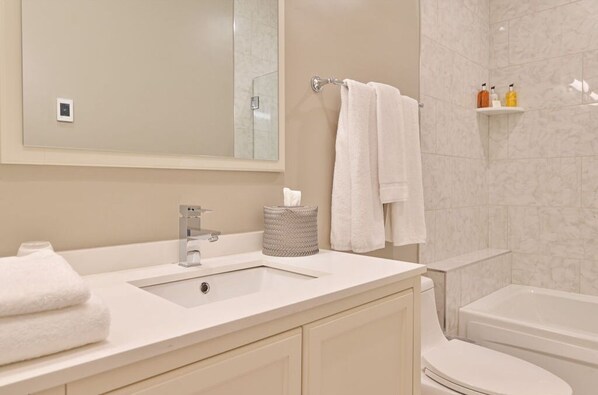 Une salle de bain moderne avec un lavabo, un miroir et des toilettes.