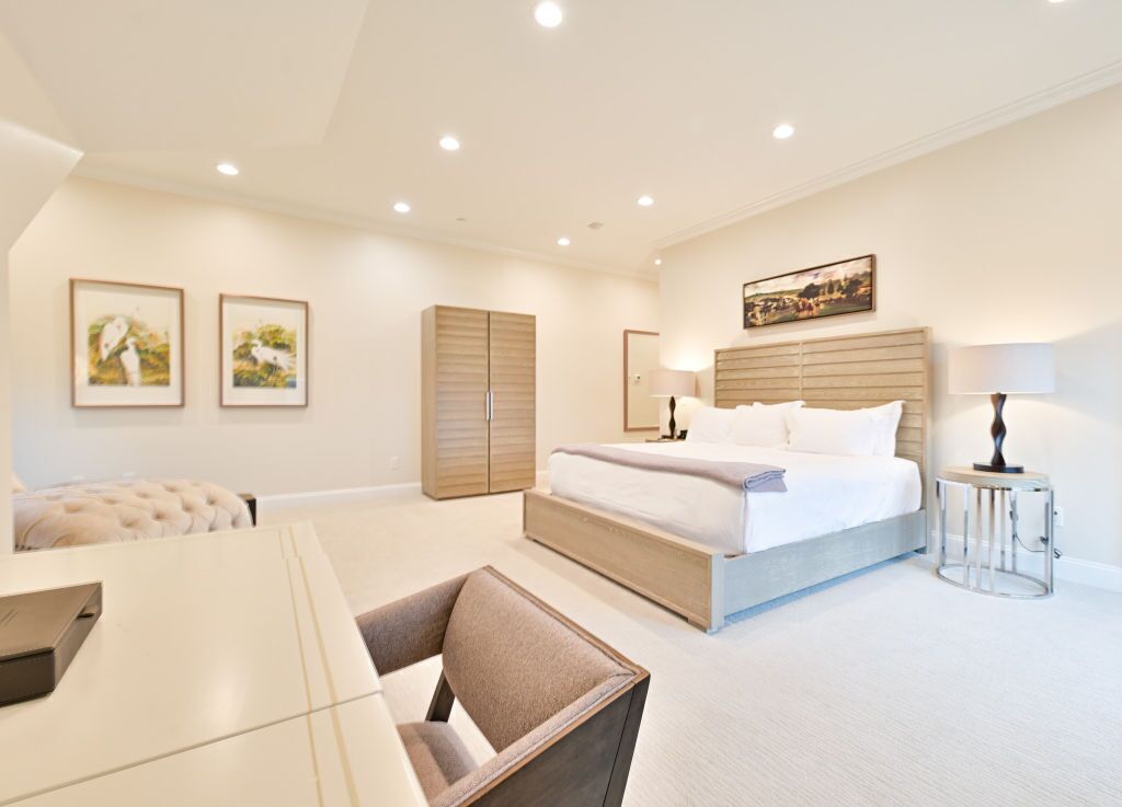 Une chambre d’hôtel moderne équipée d’un grand lit, d’un bureau, d’une chaise et d’une armoire.