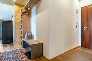 A hallway with a wooden bench, a door, and a patterned rug. - Chalet 'Panorama' with Mountain View, Private Terrace and Wi-Fi (Kastelruth)