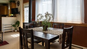 A dining area with a wooden table, chairs, and a vase of flowers. - Alpenglow One Bedroom One Bath A18 (Ouray)