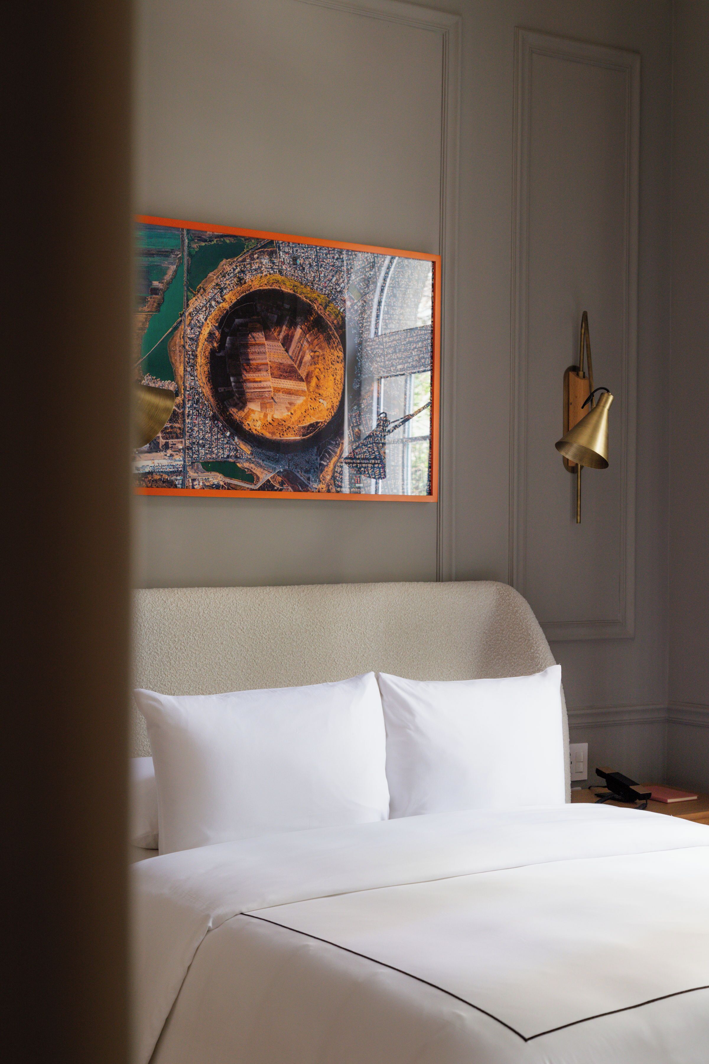 A neatly made bed with white linens in a hotel room.
