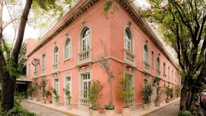 Un edificio rosa con finestre ad arco e un orologio.