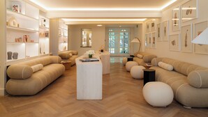 A modern living room with a herringbone wood floor, beige sofas, and a central coffee table. - Casona Roma Norte (Mexico City)