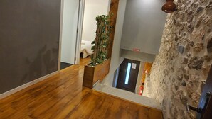 A wooden floor, a stone wall, and a plant in a planter.