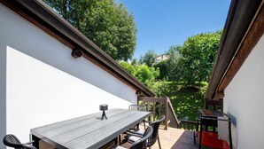 A patio with a table and chairs, a small table, and a staircase leading to a garden. - Apartment 'Appartamento Rupestre  2.0' with Private Terrace, Private Garden and Wi-Fi (Manerba del Garda)