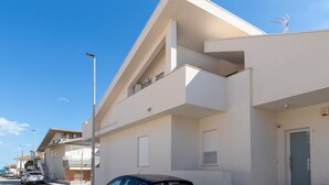 A modern building with a flat roof, a visible antenna, and a door on the right side.