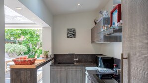 Una cucina moderna con forno integrato, microonde e lavello.