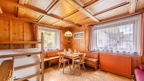Een houten interieur met een eettafel, banken en een radiator.