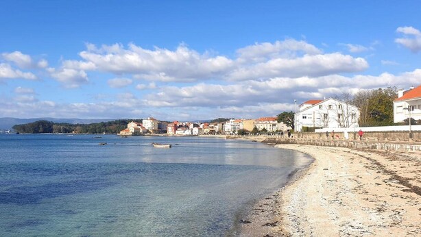 A coastal town with a sandy beach, clear blue sea, and buildings along the shore. - Holiday Home 'Fogar Da Roda' with Private Terrace, Balcony and Wi-Fi (Vilagarcia de Arousa)