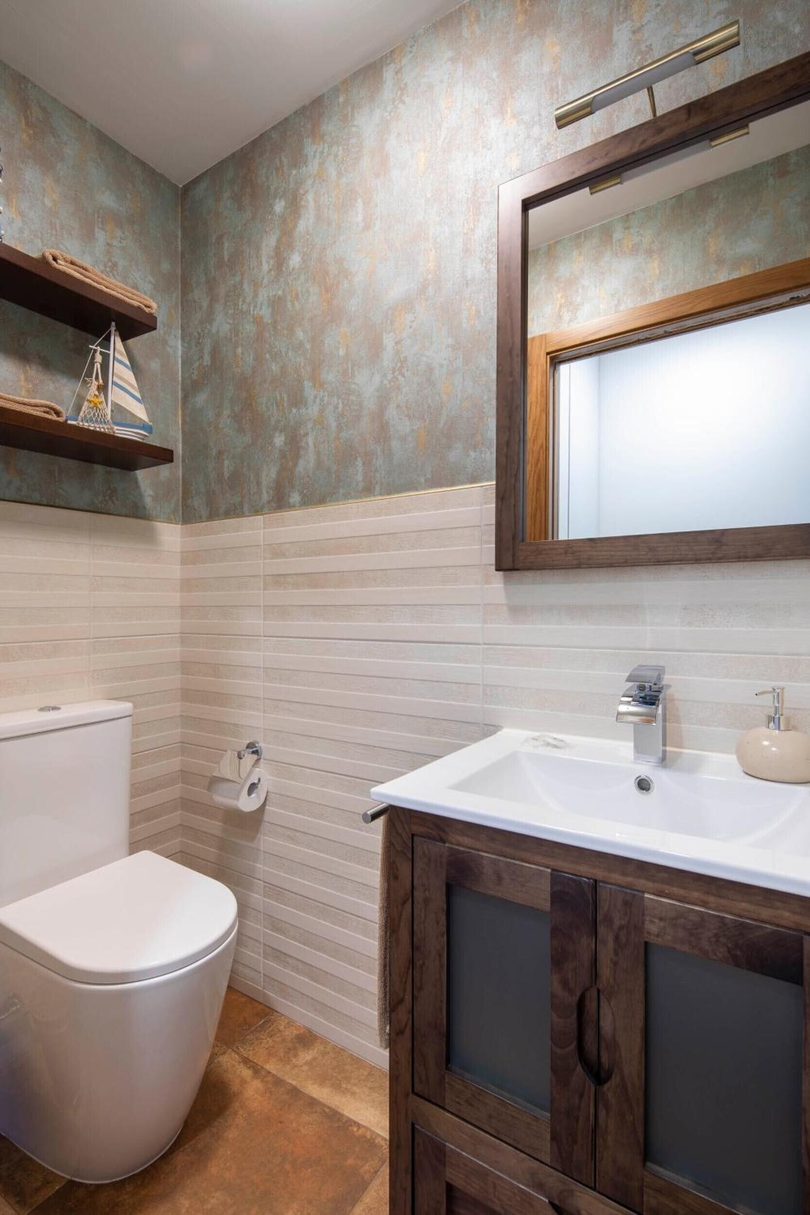A bathroom with a toilet, sink, and mirror.