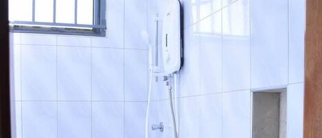 Een douche, handdoeken, zeep, shampoo