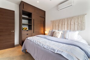 Une chambre à coucher avec un lit, une armoire et un rideau en macramé.