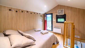 A bedroom with a bed, pillows, a TV, and a window. - Chalet 'Gîte Le Pieraline' with Mountain View, Private Terrace and Wi-Fi (Ventron)