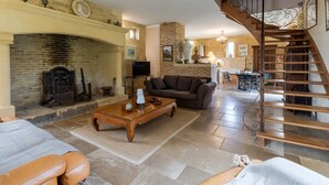 A living room with a fireplace, a sofa, a coffee table, and a staircase.