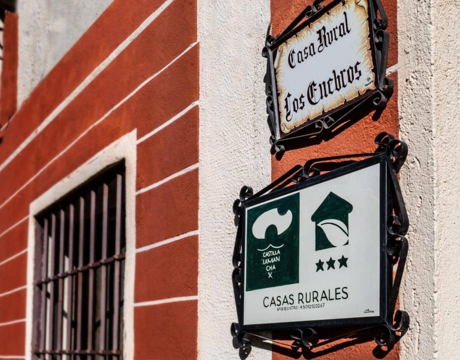 A building with a sign that reads 'Casa Rural Los Encinos' and another sign indicating 'CASAS RURALES' with a logo and stars.