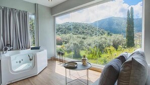 A modern bathroom with a bathtub, a sink, and a large window offering a view of a mountainous landscape. - Villa 'Boat' with Sea View, Wi-Fi and Air Conditioning (Ellomeno)