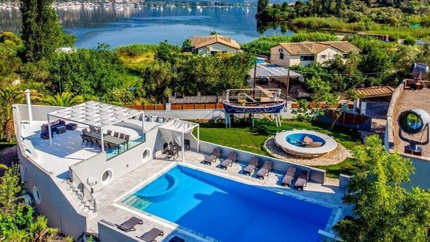 A resort with a large pool, outdoor seating, and a view of a lake and mountains. - Villa 'Boat' with Sea View, Wi-Fi and Air Conditioning (Ellomeno)