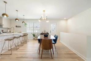A modern kitchen with a central island, bar stools, and pendant lighting. - Casa Amigos • Easy Access to ATL • Truist • Airport (Smyrna)
