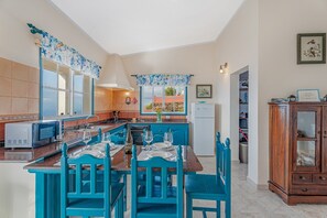 Une cuisine équipée d’une table à manger pour deux personnes, d’un four à micro-ondes et d’un réfrigérateur.