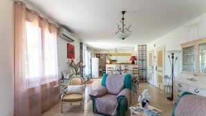 Una sala de estar con sofá, sillón y comedor con mesa y sillas.