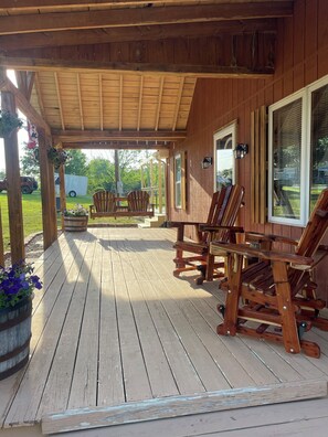 A wooden deck with outdoor seating and a covered area. - Lake House at Nolin Lake in Cub Run, KY Private Boat ramp near Mammoth Cave (Cub Run)