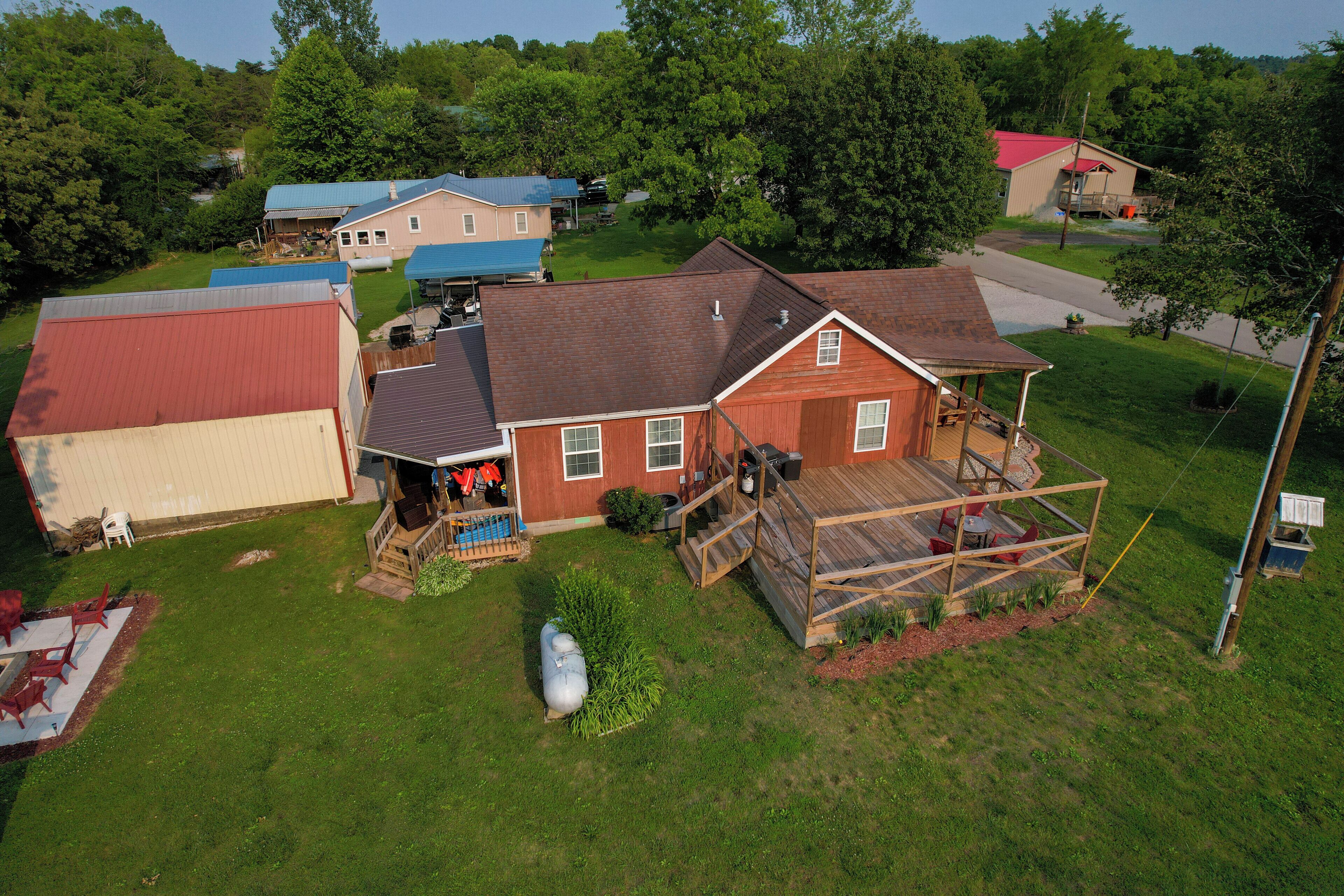 A residential property with a large deck, a garage, and a well-maintained lawn.