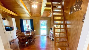 Un interior de madera con comedor, cocina y escalera.