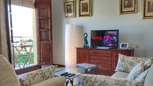 Una sala de estar con un sofá, una mesa de centro, un televisor y un aparador.