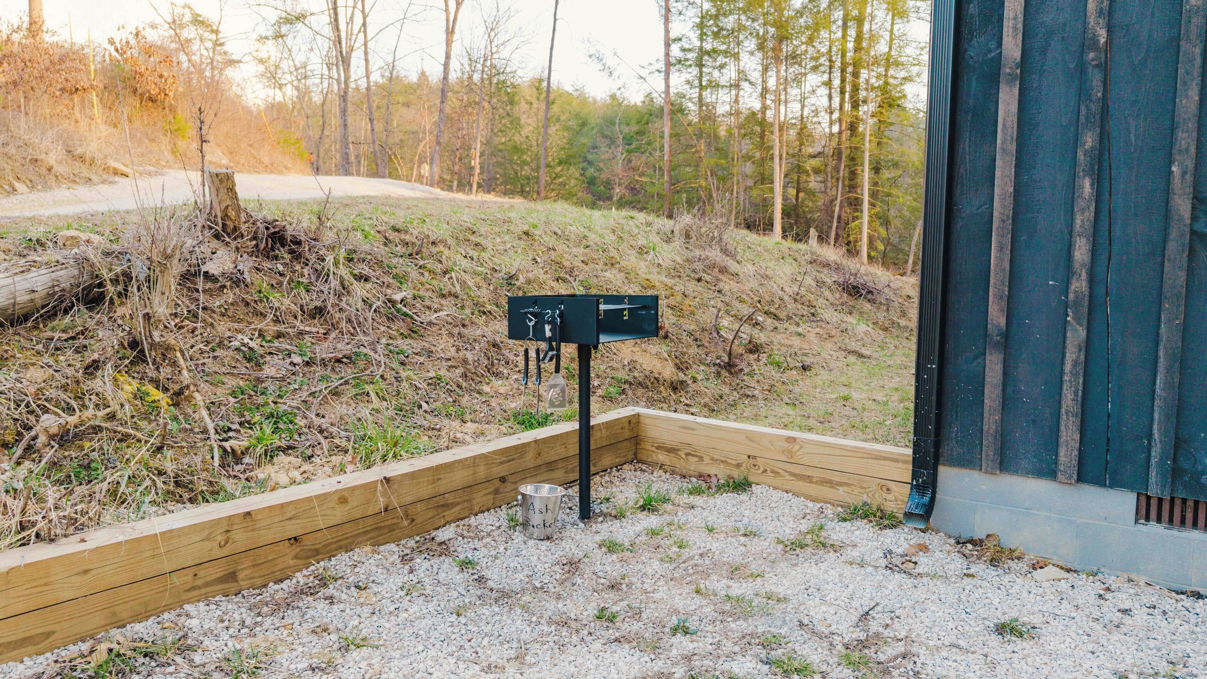 A wooden deck with a gravel path leading to a metal signpost.