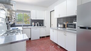 Een moderne keuken met witte kastjes, een roestvrijstalen fornuis en een raam voor natuurlijk licht.