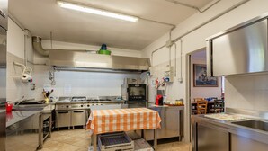 A commercial kitchen with stainless steel appliances, a tiled floor, and a cart with storage bins. - Holiday Home 'Podere Calistri' with Mountain View, Wi-Fi and Air Conditioning (Larciano)