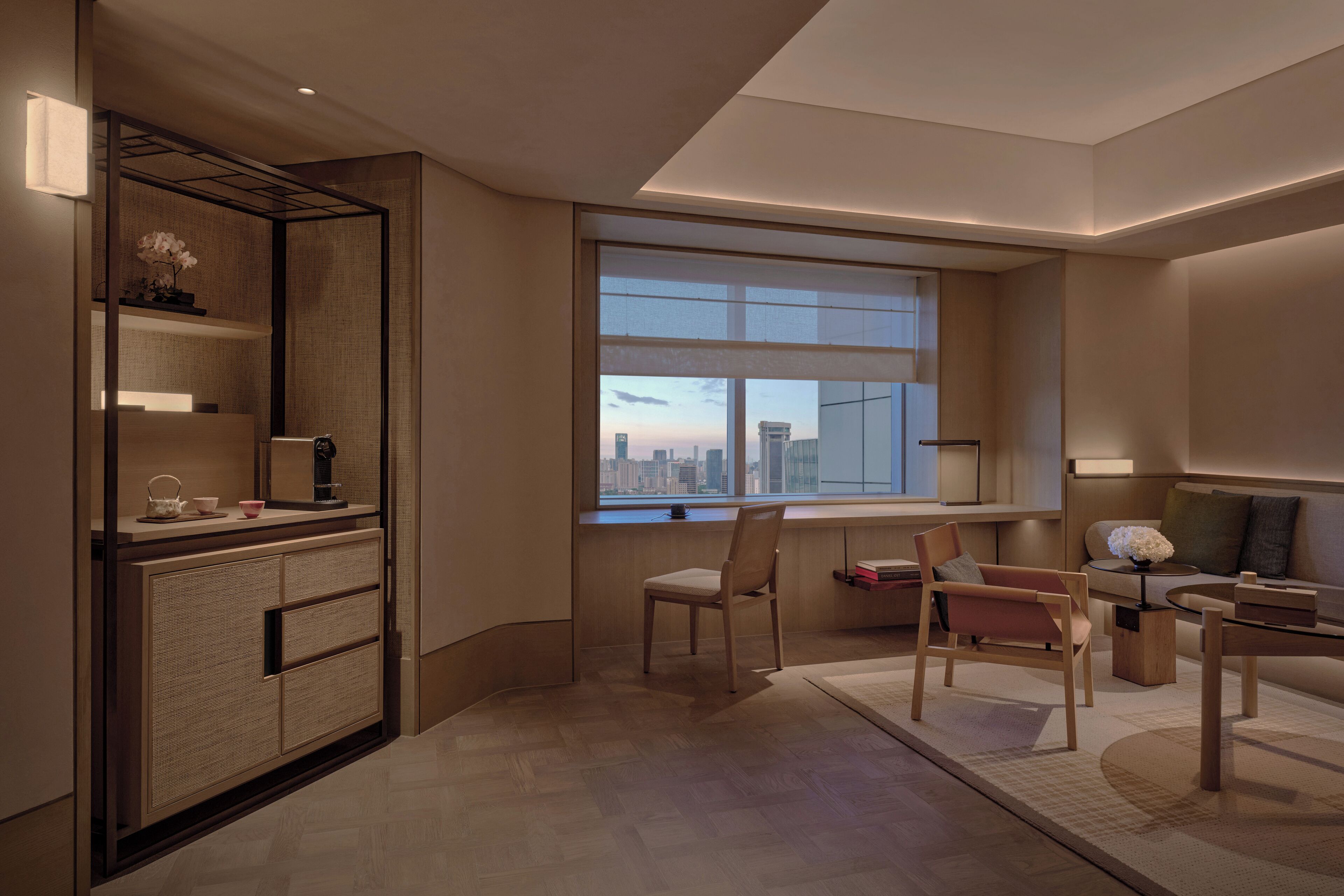 A modern living room with a large window, a sofa, a coffee table, and a side table.