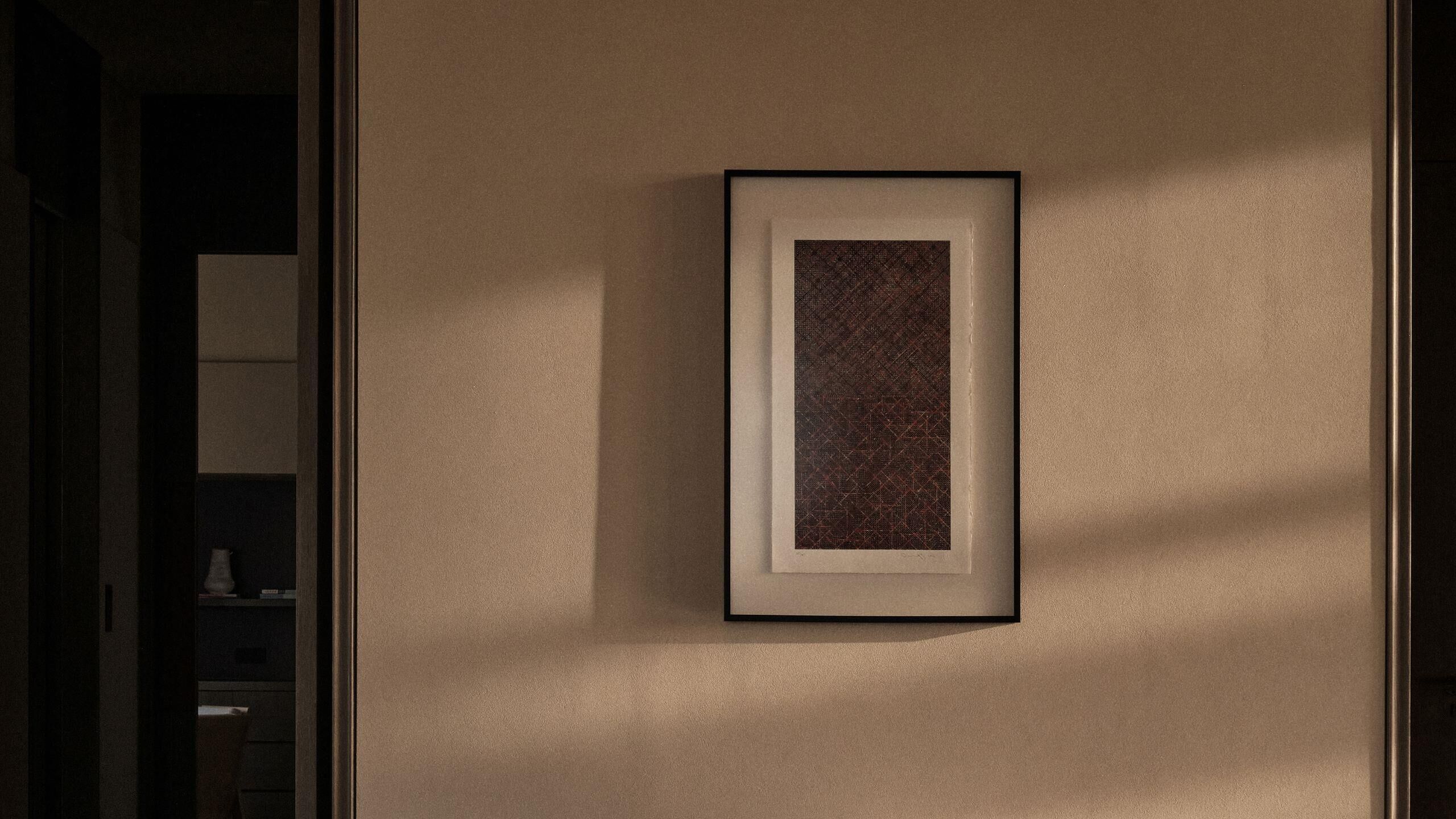 A framed artwork on a wall.