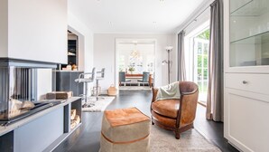 Une cuisine moderne dotée d’une cuisinière intégrée, un coin repas avec une table et des chaises, et un fauteuil en cuir.