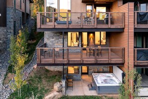 A modern two-story building with a balcony, outdoor seating, and a hot tub. - Winter Park Resort Villa 211 I Private Hot Tub I Great Views I Arcade I Discounted Attractions (Winter Park)