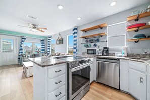A modern kitchen with a central island, stainless steel appliances, and a view of the outside. - DOG FRIENDLY, 8 BEDROOM DUPLEX, PRIVATE POOL (Gulf Shores)