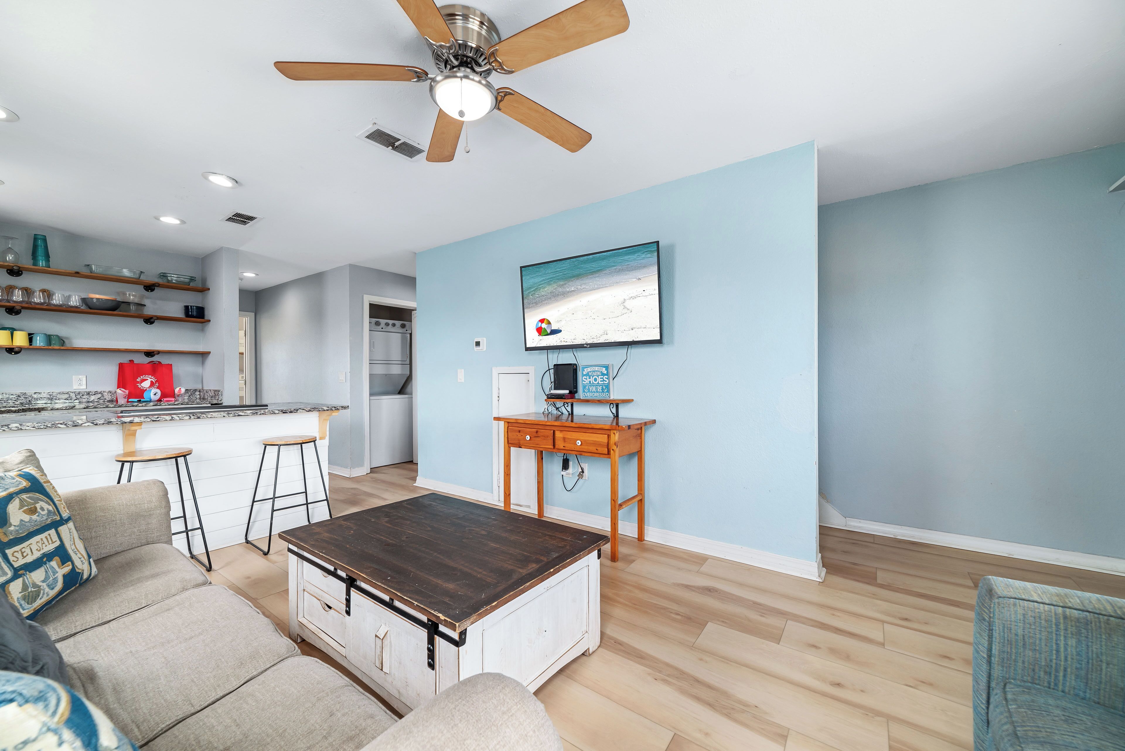 A modern living room with a sofa, coffee table, and a TV mounted on the wall.