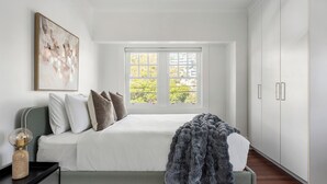 Un dormitorio con cama, ventana y armario.