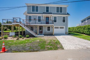 A two-story house with a front porch, a staircase, and a garage. - Slow M'Ocean – A Fresh Take on Cape Calm (Chatham)